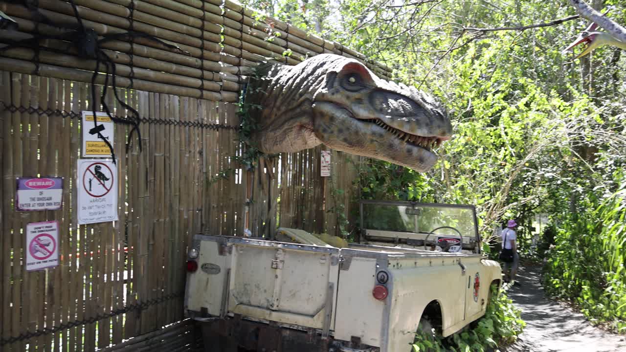 el modelo de dinosaurio se mueve la cabeza en un parque temático