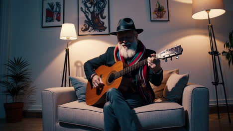 elderly man playing acoustic guitar at home