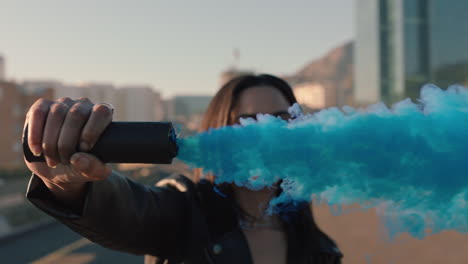 woman holding blue smoke grenade in city slow motion