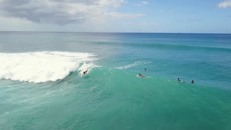 el surfista rema en la pulverización de olas grandes y talla el seguimiento aéreo inverso