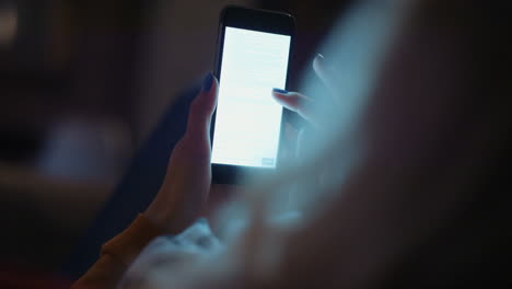 mujer leyendo un documento tarde en la noche en casa en un teléfono inteligente