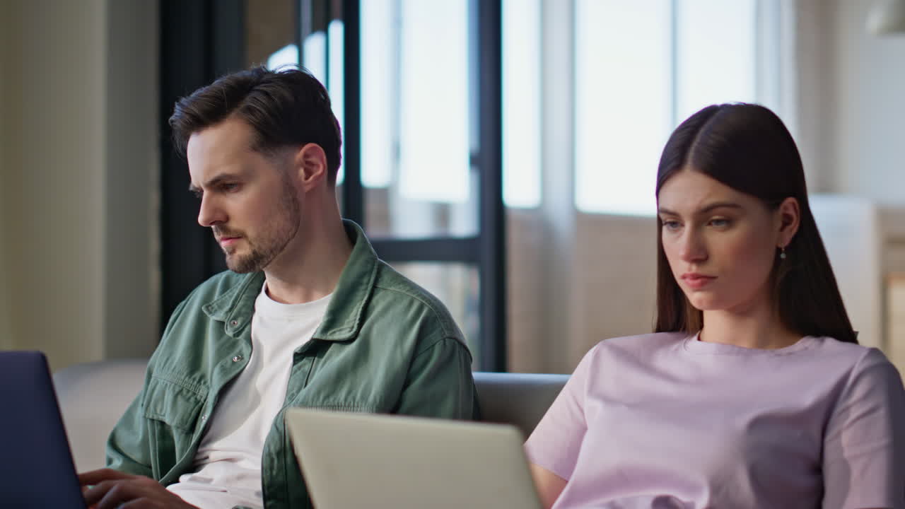 Involved people browsing laptops at living room sofa closeup. Couple working