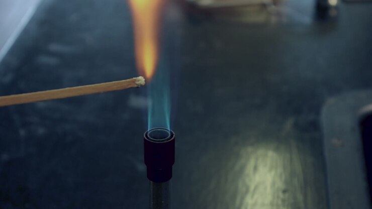 Close up of blue bunsen burner flame followed by barium flame test burning yellow