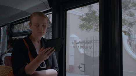 Mujer-Joven-Leyendo-Un-Lector-Electrónico-En-El-Autobús.