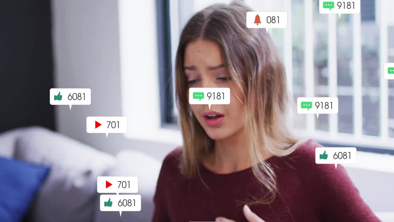 Woman reacting on living room couch, watching social media engagement icons floating around her