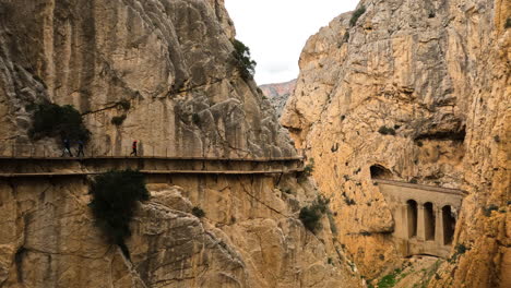 4k wide shot of a trail on the side of a mountain cliff at el caminito del rey in gorge chorro, malaga province, spain