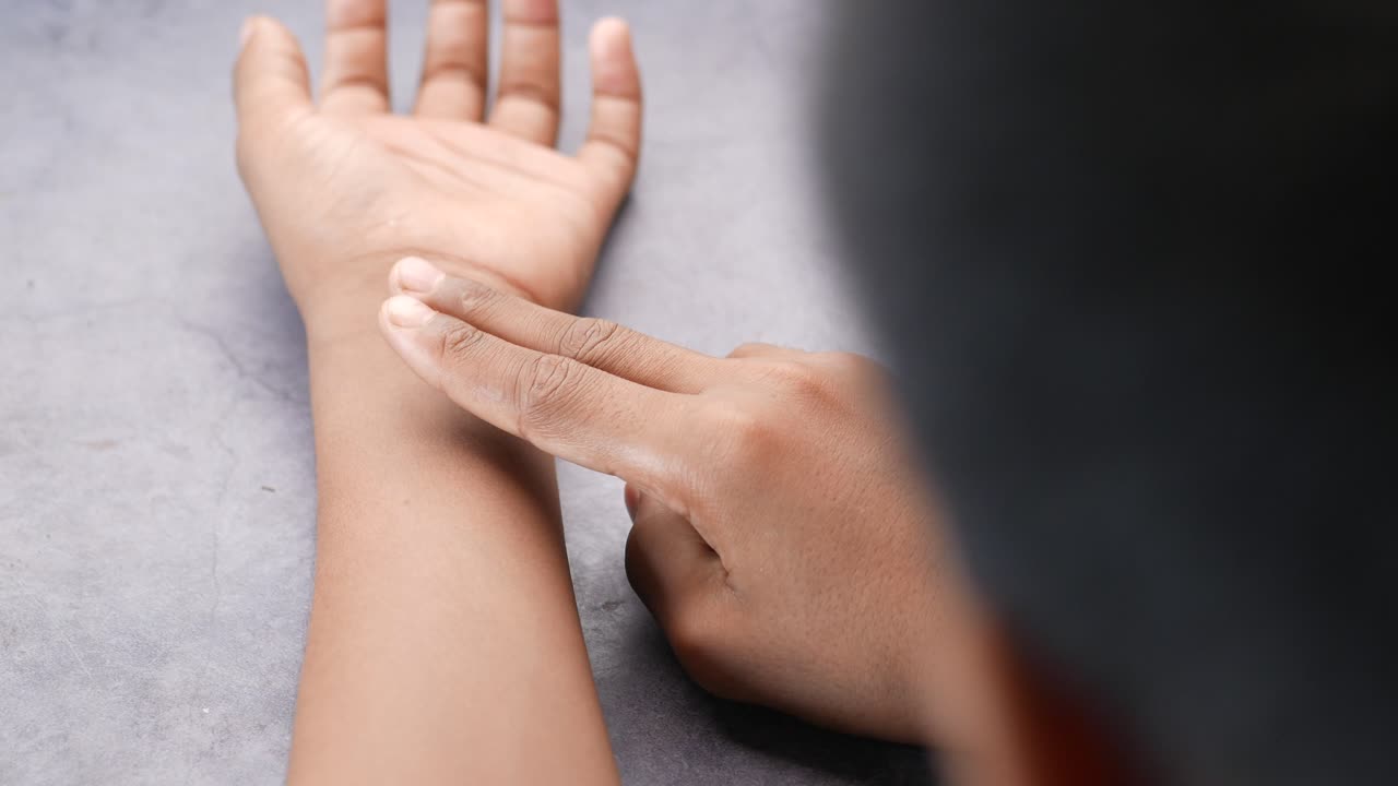 알아보지 못한 남자가 혈압을 조절하기 위해 손을 만지고 있습니다.