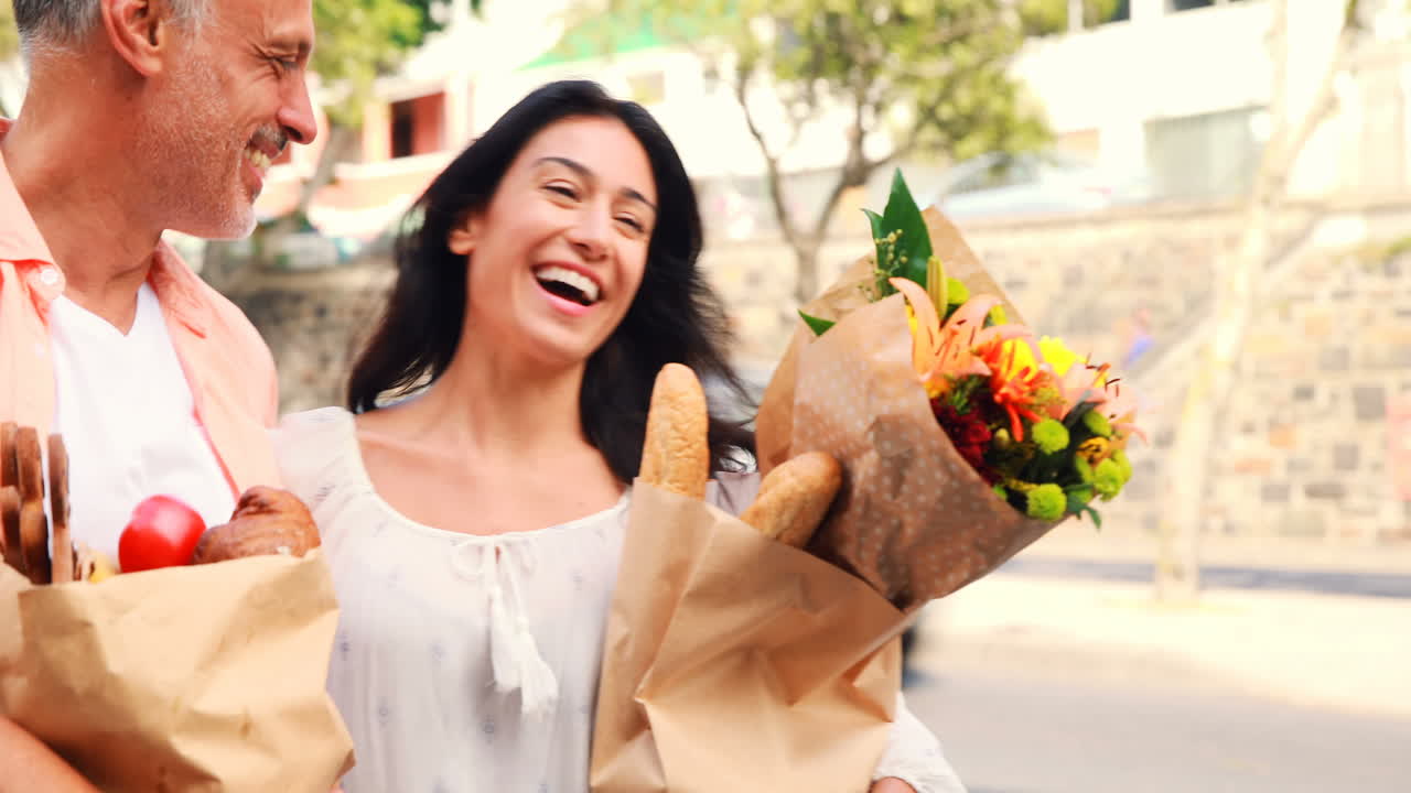 pareja sonriente con bolsas de comestibles