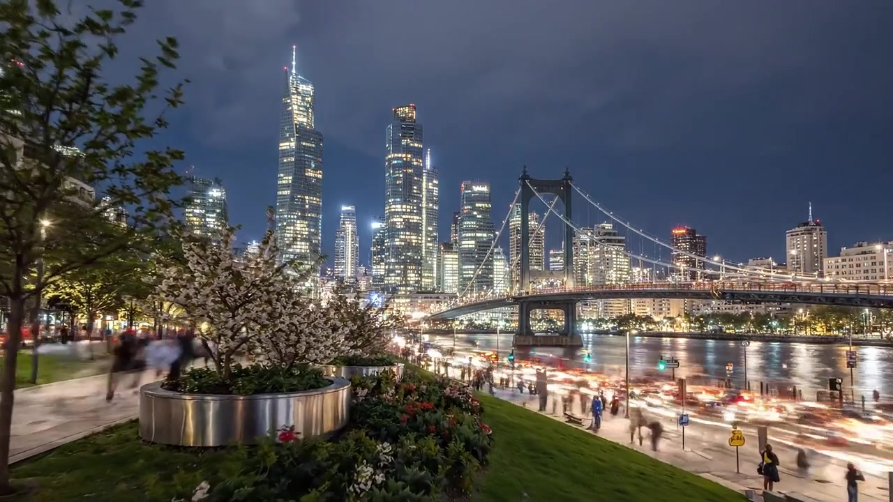 Un paesaggio urbano mozzafiato al tramonto con fiori in fiore, grattacieli scintillanti e il fiume che riflette le luci della città in una splendida vista.