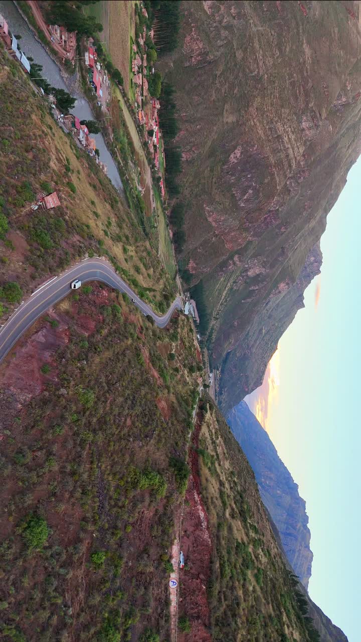 Sunset over Pisac, Peru: golden mountains, winding roads, and lush terraces in a serene aerial view
