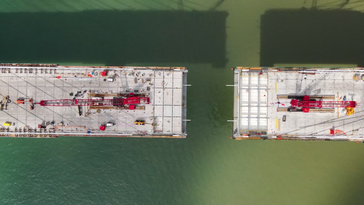 Aerial top down view of almost finished Gordie Howe Bridge crossing Detroit river