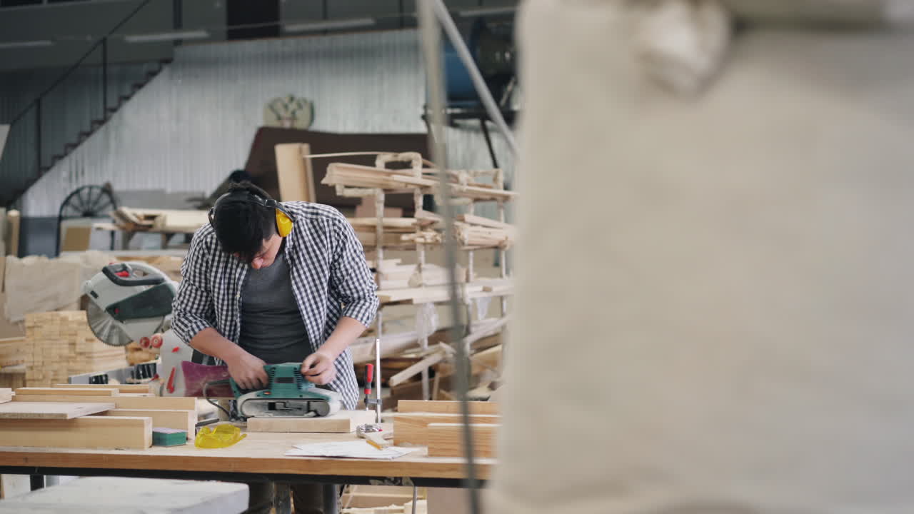 Woodworker Sanding Wood in Workshop
