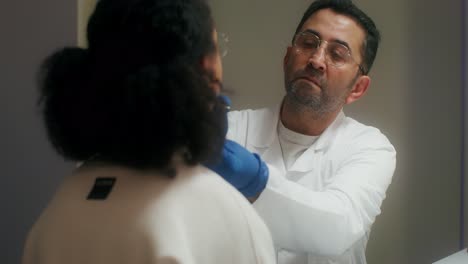 un médico examinando el cuello de un paciente