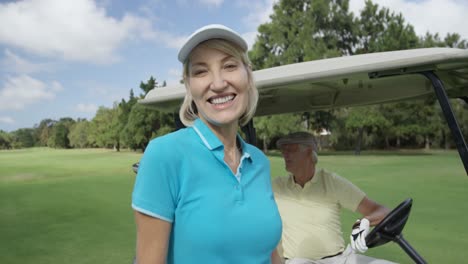 portrait of female golfer standing near golf buggy