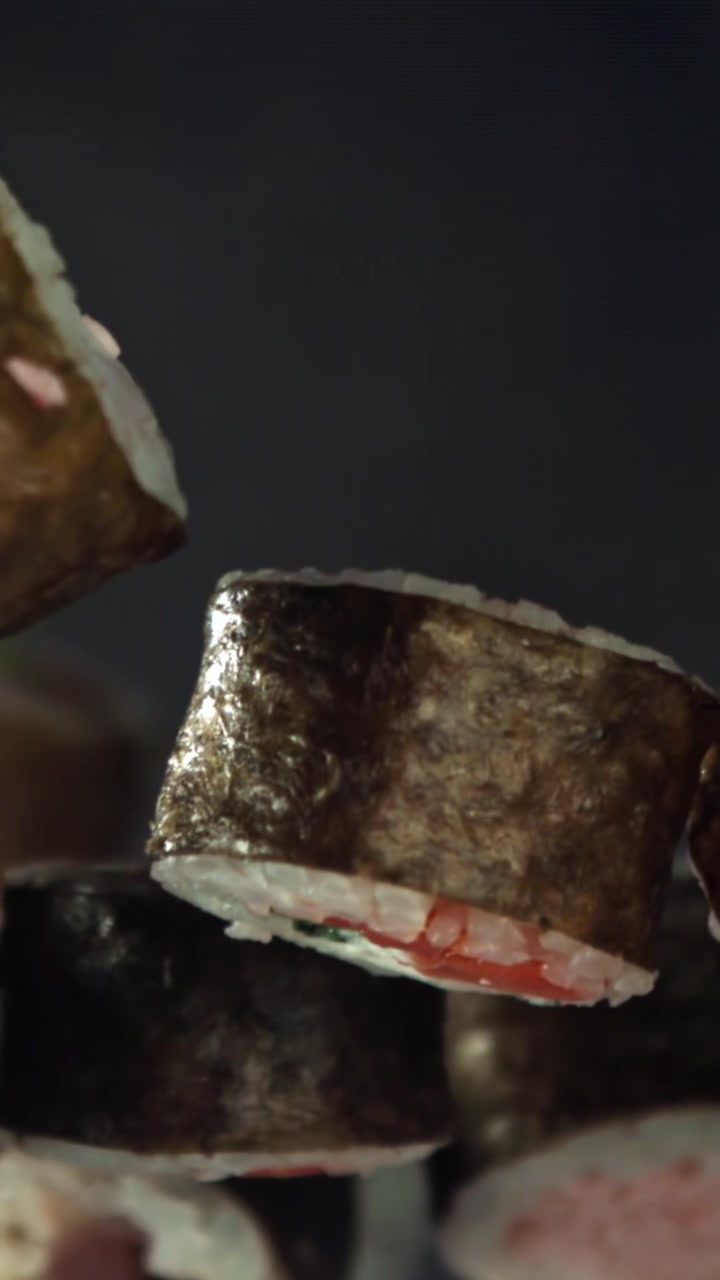 Primo piano di roll di sushi maki freschi che fluttuano su uno sfondo scuro