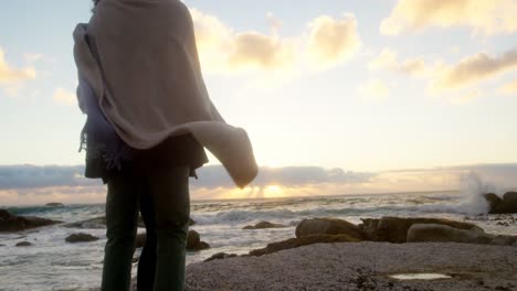 couple in blanket embracing each other at beach 4k