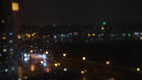 luces de la ciudad de la noche lluviosa vista desde la ventana