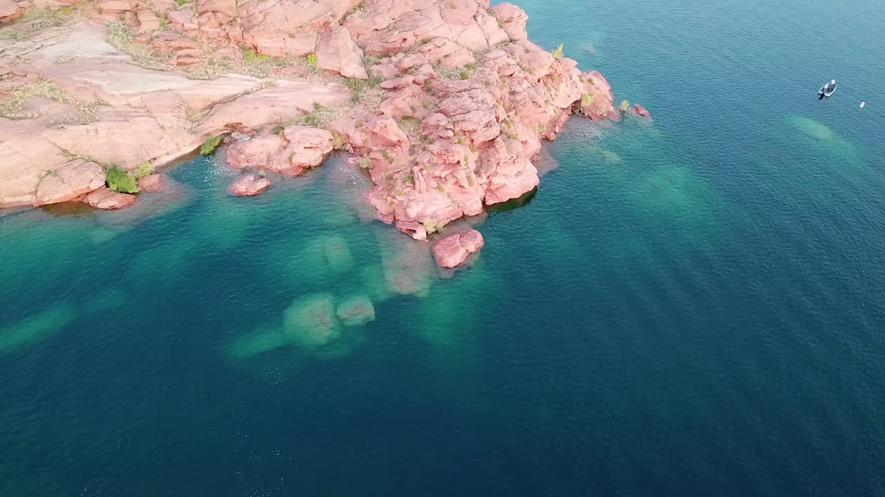 Red Rocky Island Coast, Blue Water Reservoir and Boat in Sand Hollow State Park, Utah USA, Drone Aerial View