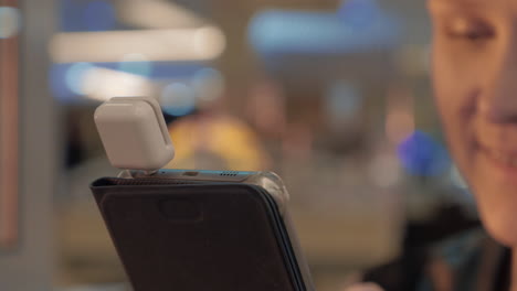 close up view of smartphone in woman hands with special dongle for paying card