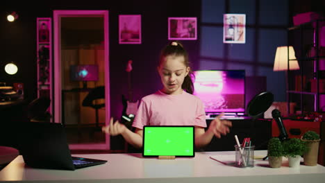 Cheerful-kid-using-chroma-key-tablet-to-present-promotion-from-media-partner-to-followers