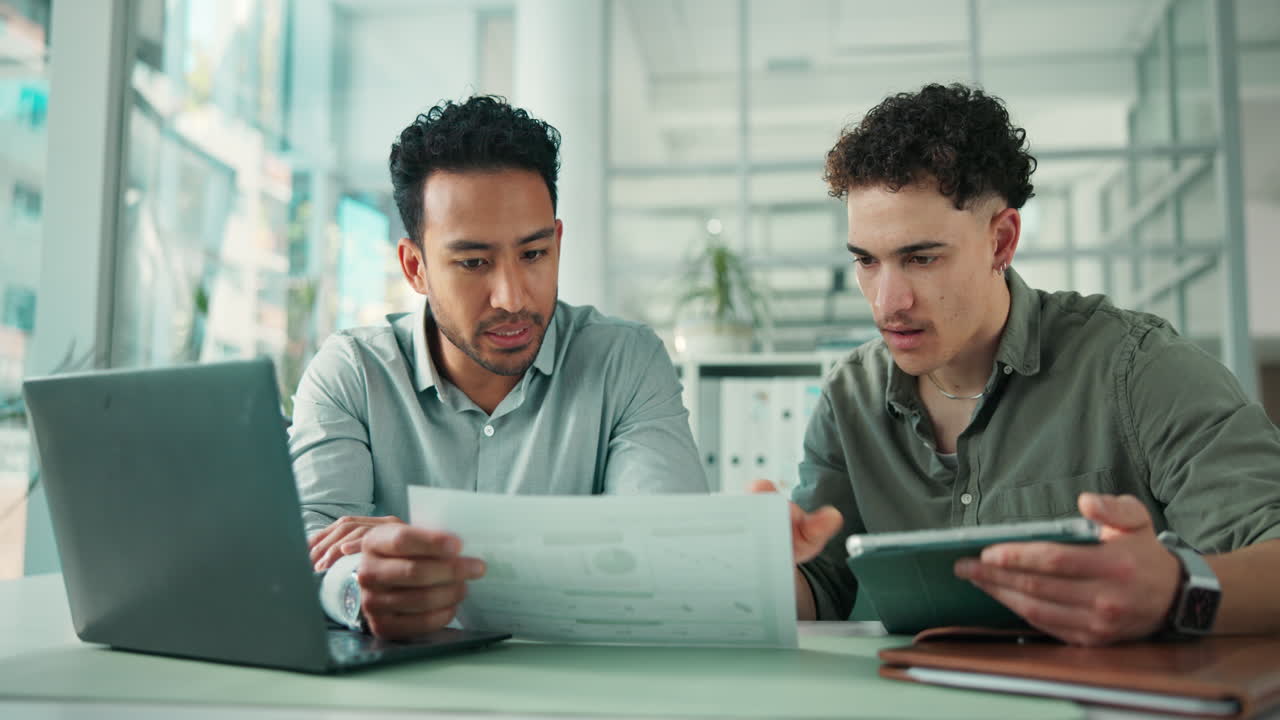 Two Businessmen Collaborating and Reviewing Documents in a Modern Office