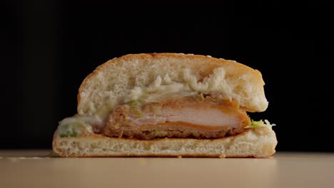 Cross-section-of-fried-chicken-burger,-another-is-placed-next-to-it