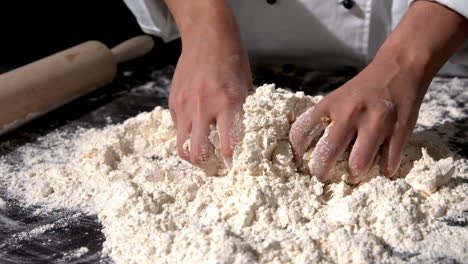 chef kneading ingredients together to form a dough