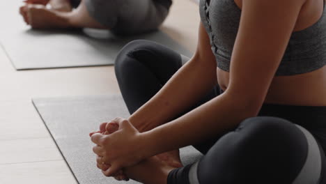 mujer de yoga saludable practicando poses joven caucásica disfrutando de un estilo de vida fitness haciendo ejercicio en el estudio con un grupo de mujeres multirraciales.