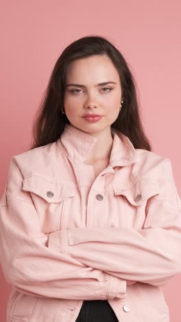 serious young woman thinking in pink studio
