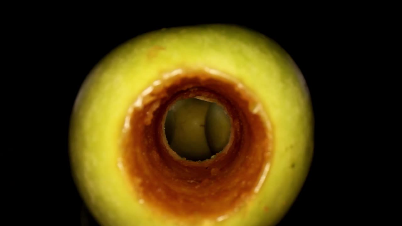 comenzando dentro del interior de un núcleo de manzana oxidado donde se muestra un vistazo de otras 3 manzanas