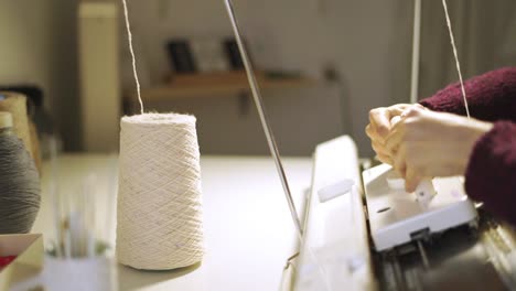 Manos-Femeninas-Trabajando-En-Una-Máquina-De-Tejer-En-La-Mesa-Del-Taller.