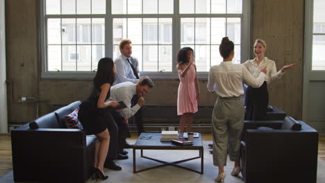 female boss and colleagues celebrating at a casual meeting