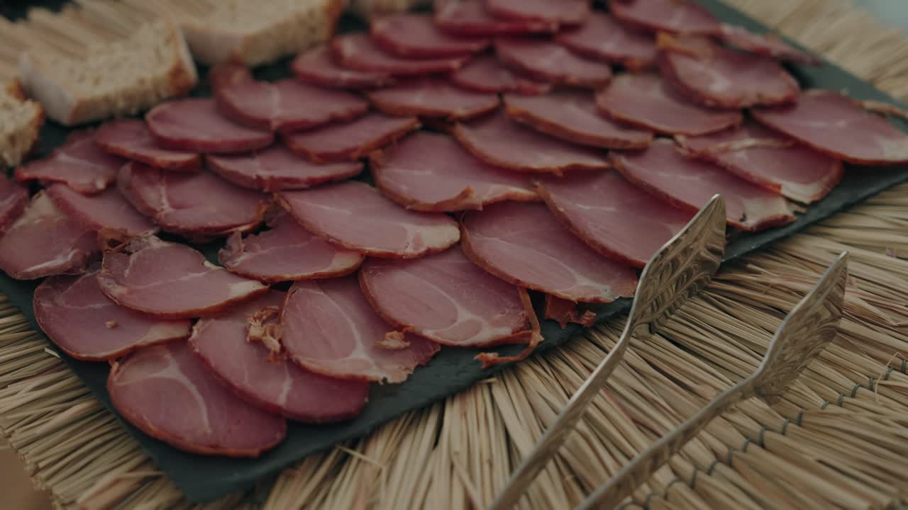 고풍스러운 슬레이트 접시에 정돈되어 놓인 염장 육류 슬라이스