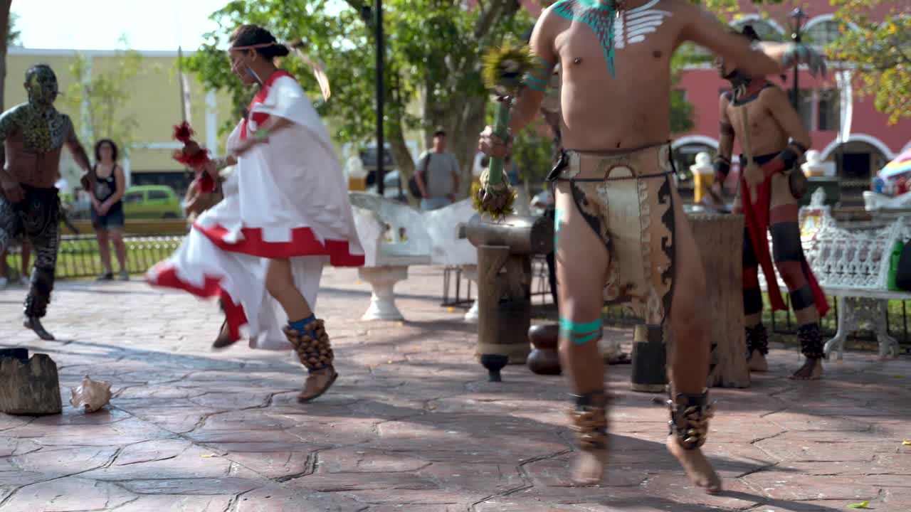 Closeup of Mayan dancers performing to live drums outside in a park in Valladolid, Mexico
