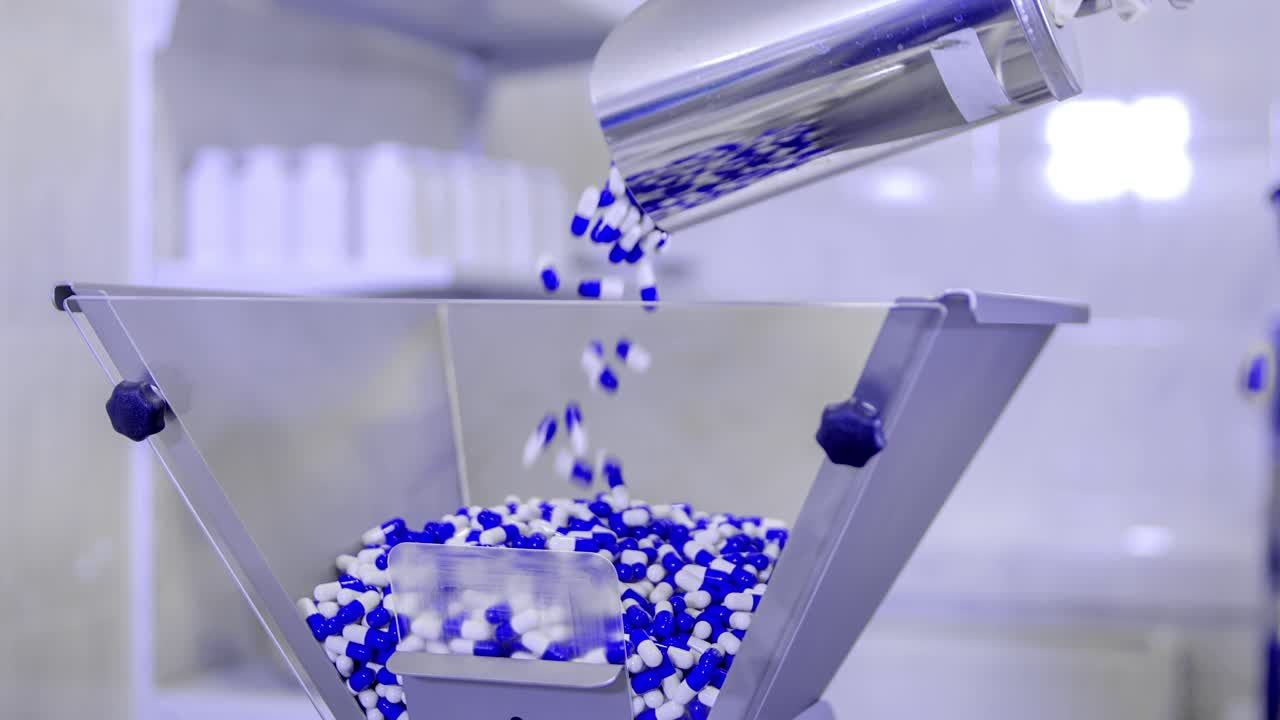 Scooping blue and white pills to cure the coronavirus into a dispenser. Man working in a laboratory