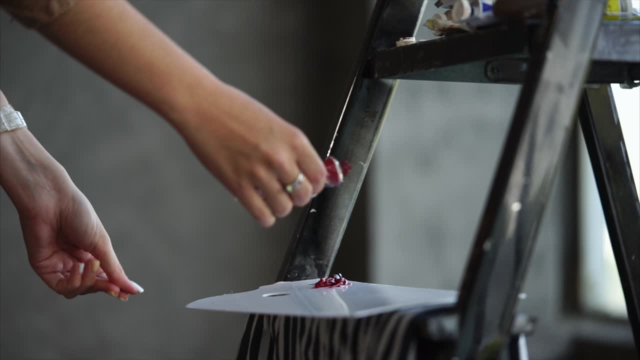 Artist mixing paint on a palette