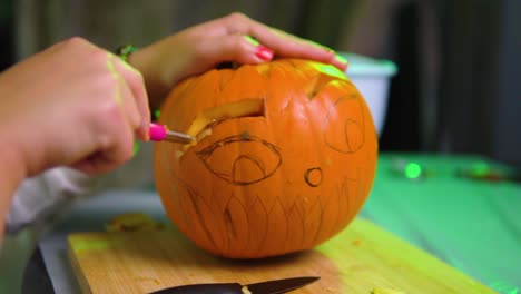 tallado tradicional de calabaza para halloween con cuchillo y otras herramientas aleatorias que se encuentran en la cámara lenta de la casa
