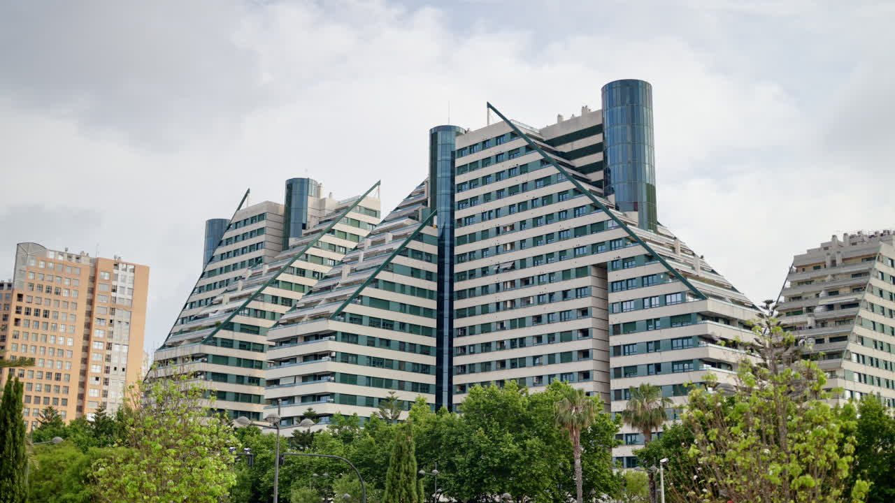 Valencia, Spain - May 28, 2025: Daytime view of stepped, triangular modern apartment blocks near the City of Arts and Sciences skyline