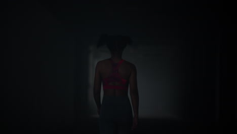 girl walking in dark corridor. athlete taking break after cardio workout