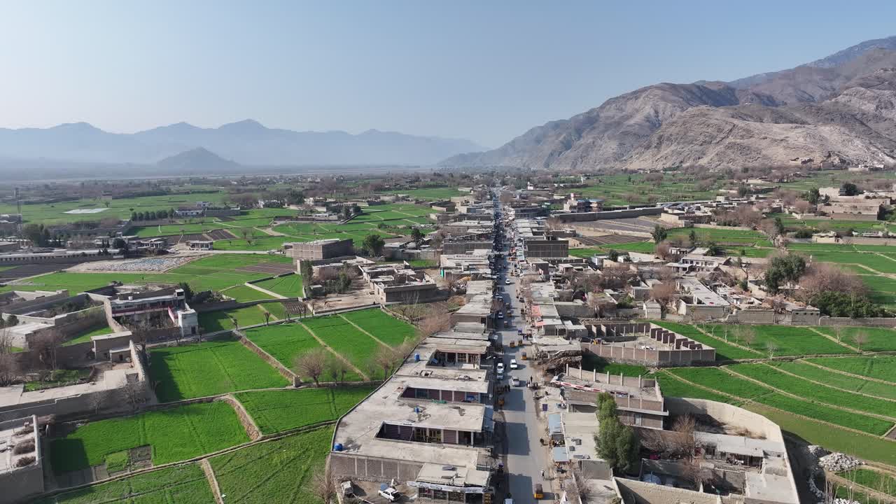 Drone Aerial over Nangahar, Nuristan village in Afghanistan - Panorama Of Lush Green, Terraced Fields with distant Mountains