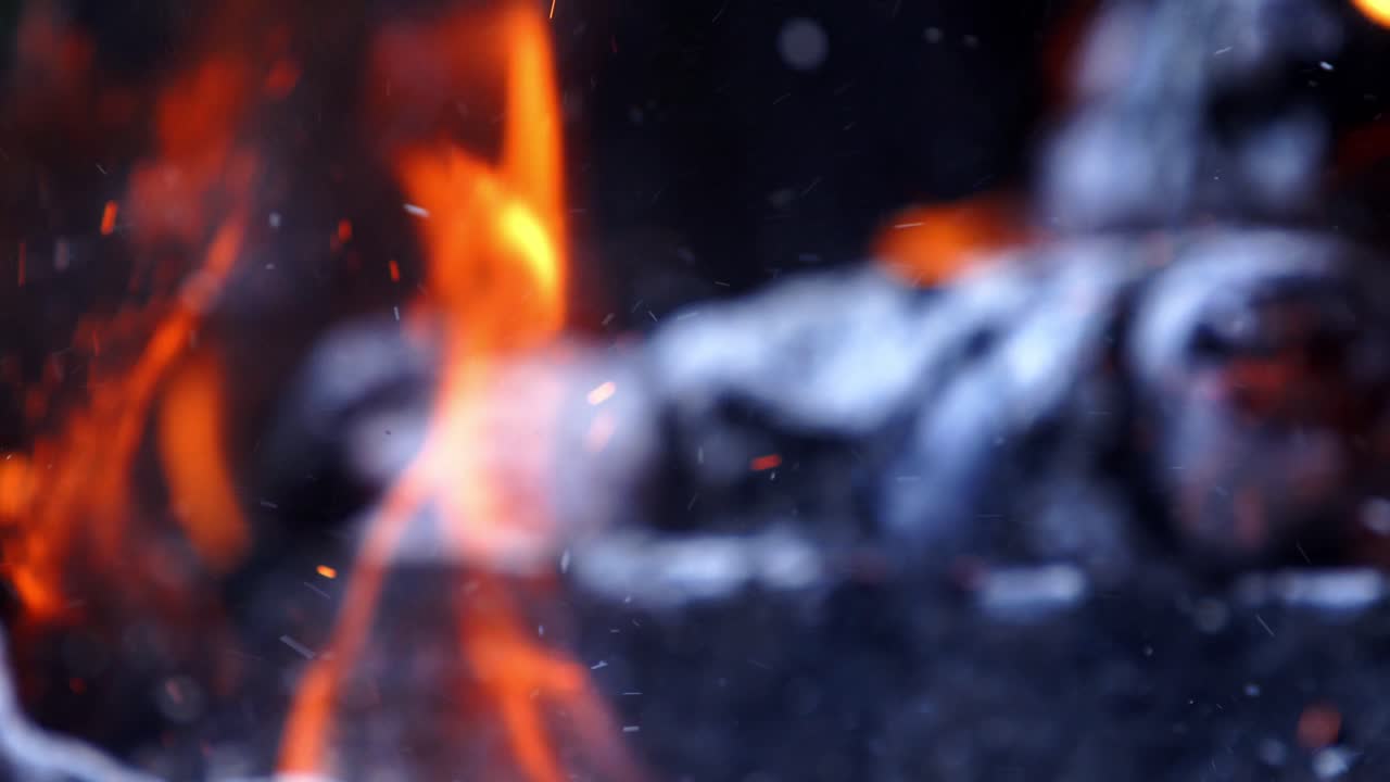 Falò. Ceppi che bruciano in fiamme arancioni. Un bel fuoco brucia intensamente. Le braci del fuoco si innalzano. Movimento lento.