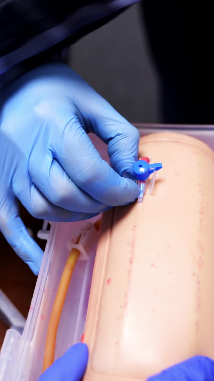 Putting the medical catheter. Learning a catheter installation on a dummy hand. Medical skills training. Close-up. Vertical video
