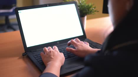 Woman-using-laptop-at-home-holding-mouse-clicking