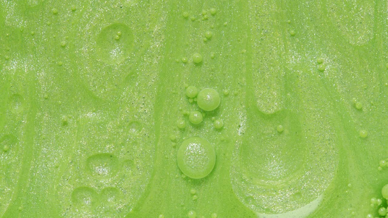 밝은 녹색 거품이 반이고 있습니다.