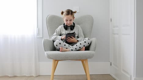 girl with headphones using the tablet