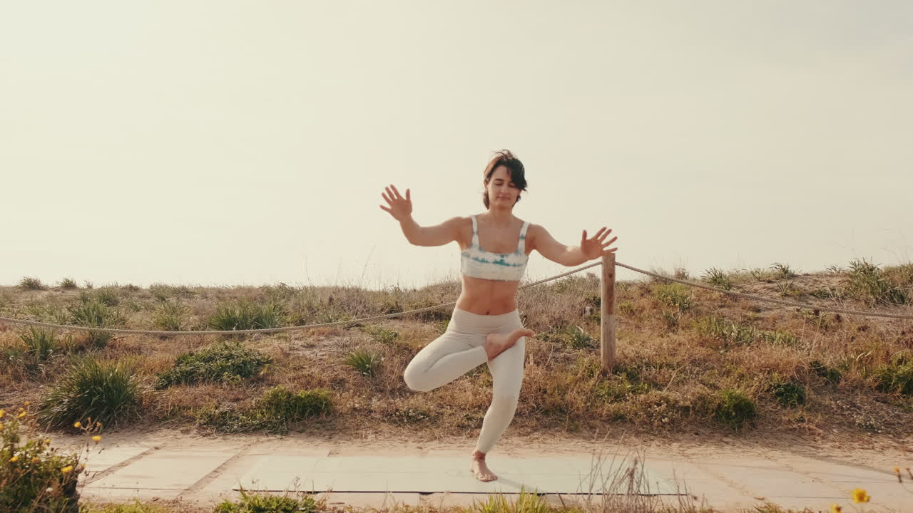 Giovane donna che pratica la posizione di equilibrio yoga all'aperto