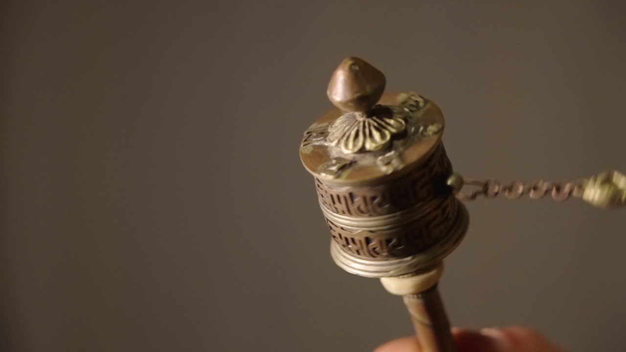 Mão Girando uma Roda de Oração Tibetana Tradicional
