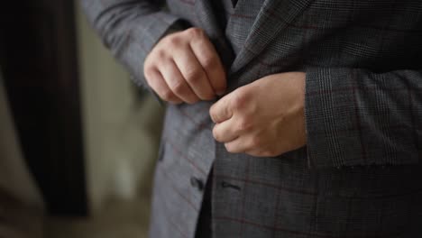 a man buttons on a stylish suit