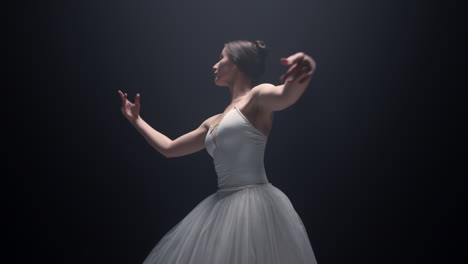 pretty ballet dancer performing on stage. flexible ballerina dancing indoors.