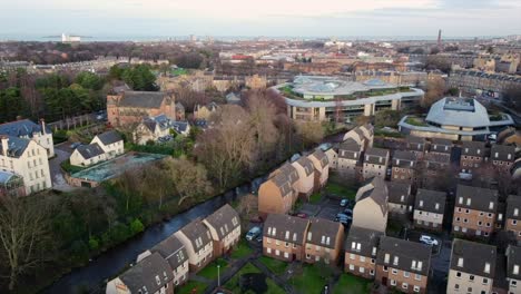 footage of edinburgh highlighting modern buildings, residential complexes, and a small river running through the area. captures urban greenery and the city’s blend of architecture in a wide view.